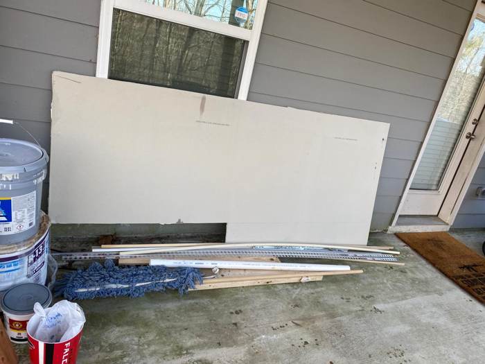 Junk and construction debris piled against a house before removal